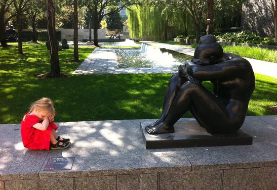 Nena junto a una estatua